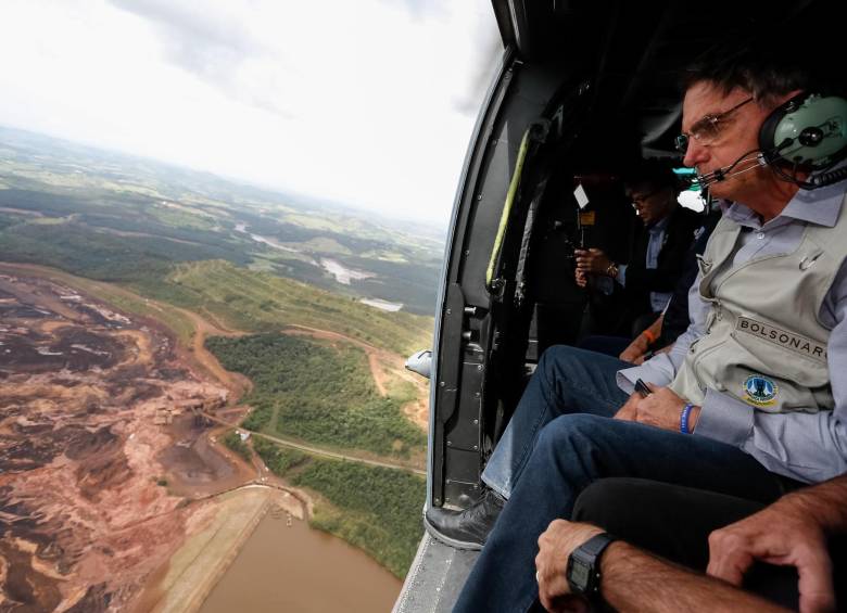 En la foto cedida por la presidencia de Brasil se observa al mandatario, Jair Bolsonaro mientras sobrevuela la zona afectada por una avalancha tras la rotura de una represa minera. Foto: EFE.