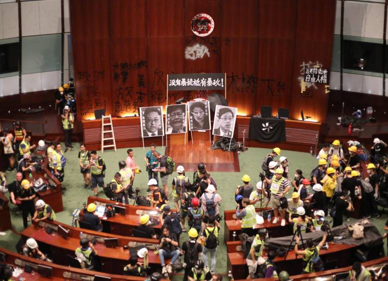Cientos de manifestantes irrumpen en el Parlamento de Hong Kong (China), este lunes. Tras pasar más de cuatro horas intentando echar abajo la entrada del edificio con barras de acero, ladrillos o piedras, los manifestantes consiguieron acceder al interior pasadas las 21.00 hora local. Foto: EFE