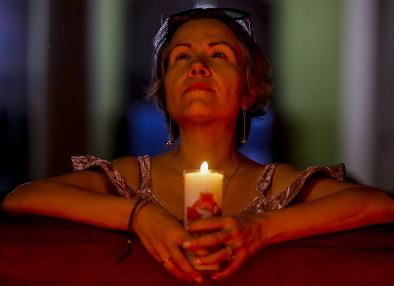 Una mujer reza dentro de la iglesia Santa Gertrudis de Envigado durante la celebración del Jueves Santo. FOTO JAIME PÉREZ
