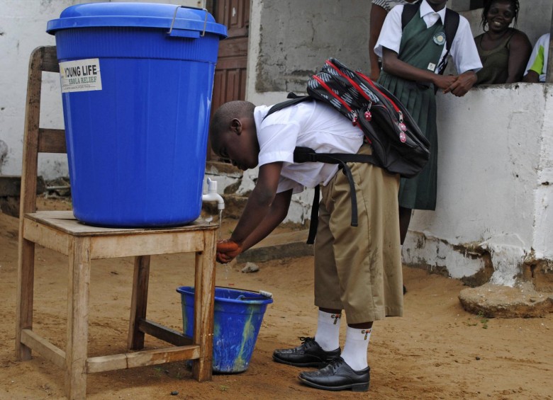 Un niño se lava las manos antes de ir a la escuela en Monrovia. Miles de niños liberianos en uniformes impecables acudieron de nuevo a la escuela, después de un paréntesis de seis meses de duración diseñado para detener la propagación del peor brote de ébola en la historia. FOTO REUTERS