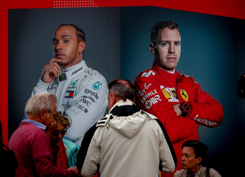 Varias personas esperan este miércoles junto a dos carteles del piloto alemán Sebastian Vettel (d) y del británico Lewis Hamilton durante un acto previo al Gran premio de Fórmula Uno de Australia que se disputará el próximo 17 de marzo, en la Plaza Federación de Melbourne, Australia. Foto: EFE