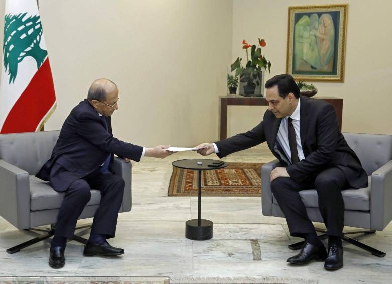 Primer ministro de Líbano Hassan Diab (derecha) presentó su renuncia al presidente Michel Aoun (izquierda) en el palacio presidencial en Baabda. No se sabe cuándo serán las elecciones. FOTO AFP
