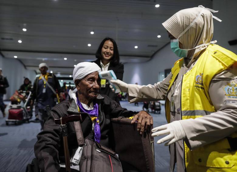 Indonesia: una agente de salud del aeropuerto internacional de Soekarno-Hatto le toma la temperatura a los pasajeros que llegan al país para descartar la presencia del virus chino que causa neumonía. Foto: EFE