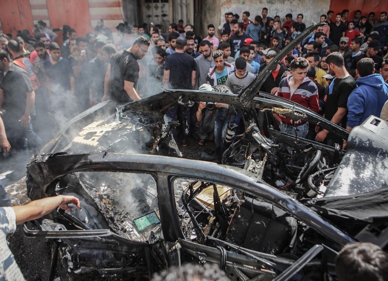 Palestinos inspeccionan el automóvil destruido del miembro de Hamas, Hamed Al-Khodari, después de ser golpeado por un ataque aéreo israelí en la ciudad de Gaza este 5 de mayo de 2019. Foto Efe.