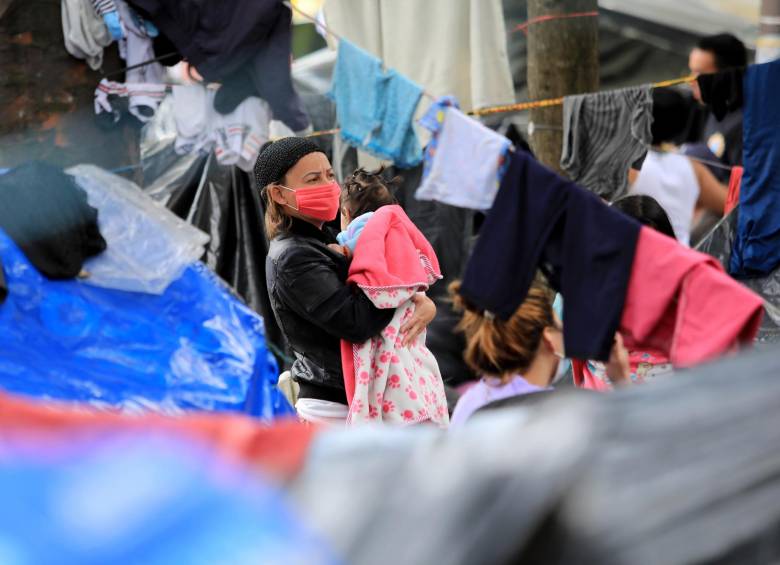 Una mujer y su bebé en un campamento improvisado donde los inmigrantes venezolanos desempleados y sin hogar permanecen durante la pandemia, en Bogotá. FOTO AFP