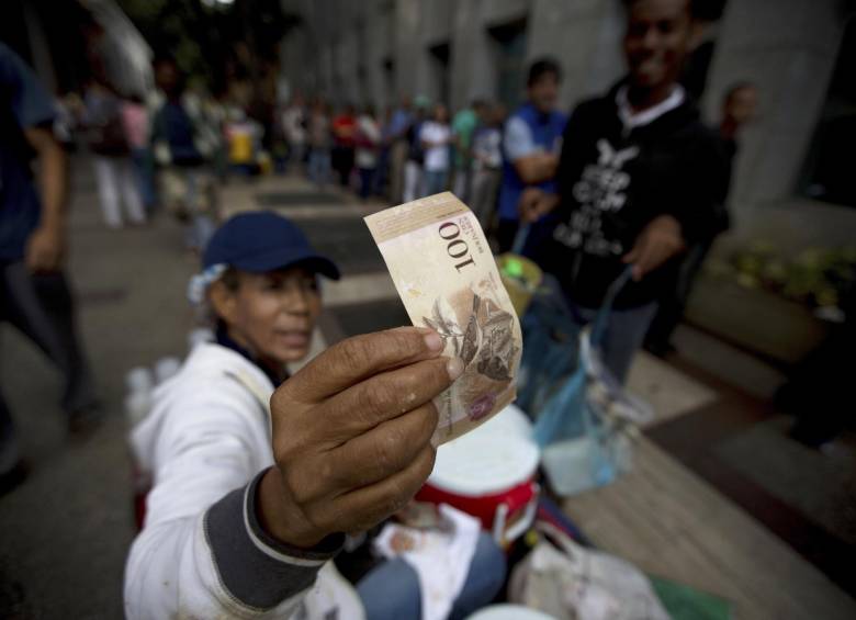 Este martes, los venezolanos hicieron filas durante horas para entregar los billetes de 100 bolívares en las sucursales bancarias. FOTO AP