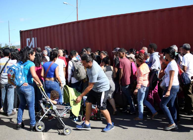 Las personas se mueven este sábado entre los contenedores. FOTO REUTERS