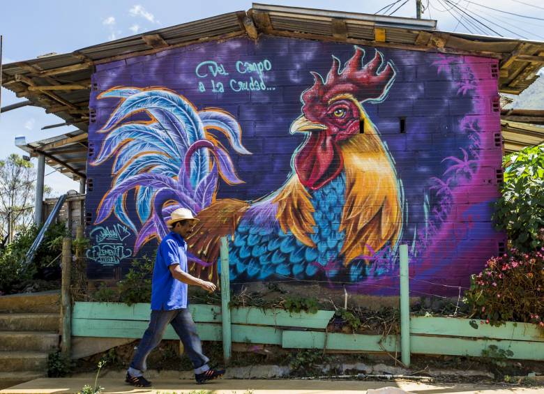 Oscar Darío Zapata camina frente a uno de los murales que decoran el barrio. FOTO JAIME PÉREZ