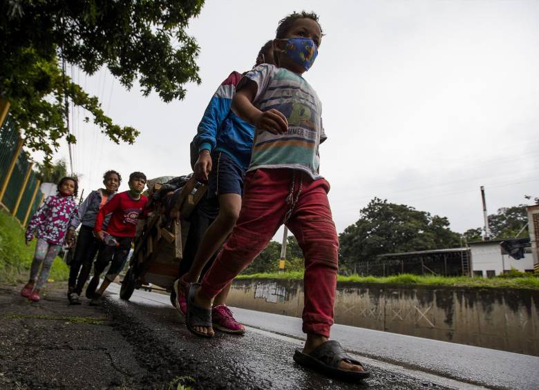Caminantes venezolanos cruzan por la Autopista Norte que conduce a la costa Atlántica. FOTO: JULIO CÉSAR ECHEVERRI
