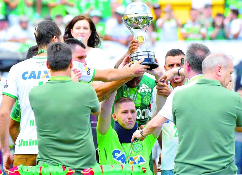 Los sobrevivientes del accidente Jackson Follmann (centro), Helio Neto y Alan Rushel, levantaron el pasado sábado el trofeo de la Copa Sudamericana, campeonato que les da cupo a la Suruga Bank. FOTO AFP