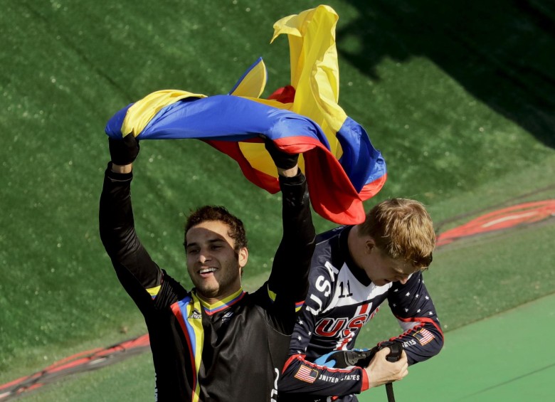 Cuando los jueces le confirmaron que era el ganador del bronce, Carlos Alberto se arrodilló y desde la tribuna le lanzaron la bandera tricolor para celebrar su triunfo. FOTO AP