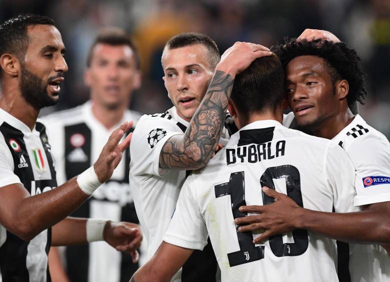 Juan Guillermo se abraza con Dybala, la gran figura ayer en la segunda jornada de la fase de grupos de la Liga de Campeones. El colombiano llegará en buen nivel a la Selección. FOTO AFP 