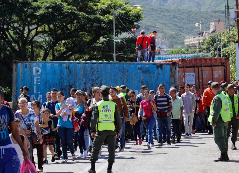 Miembros del GNB junto a las personas que cruzan la frontera. FOTO AFP