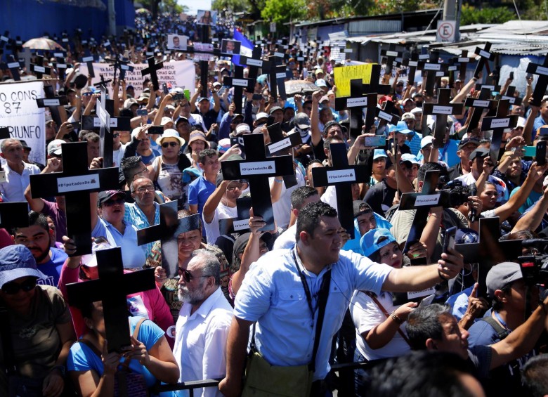 Simpatizantes del presidente de El Salvador, Nayib Bukele, marcharon por las calles de la capital enarbolando cruces con los nombres de legisladores opositores. FOTO AFP