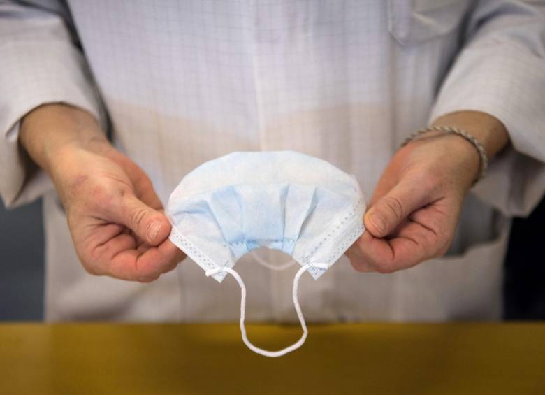 Un empleado controla máscaras de protección de la salud en una cadena de producción. FOTO AFP