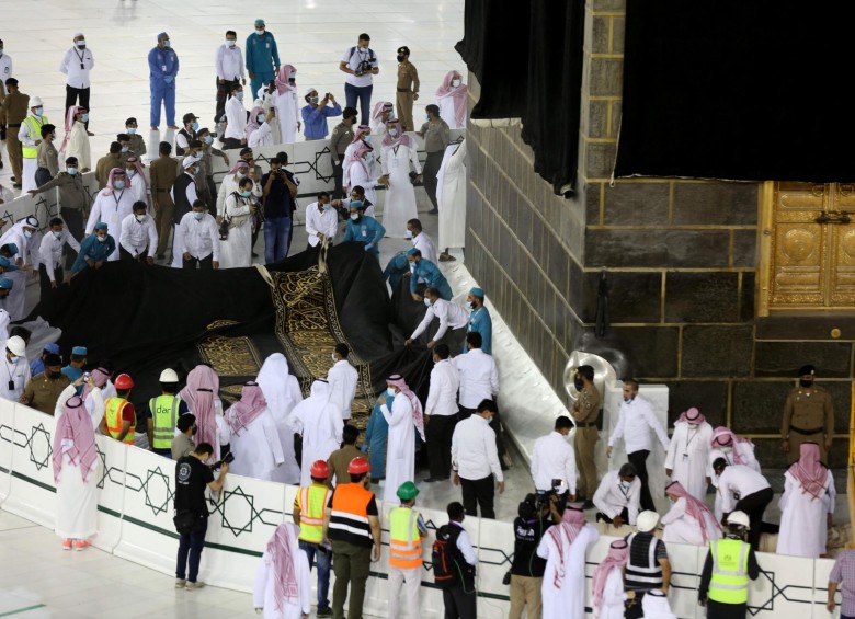 Los trabajadores sauditas pusieron el nuevo Kiswa, la cubierta protectora que envuelve la Kaaba, hecha de seda negra e hilo dorado y bordada con versos del Corán. FOTO AFP