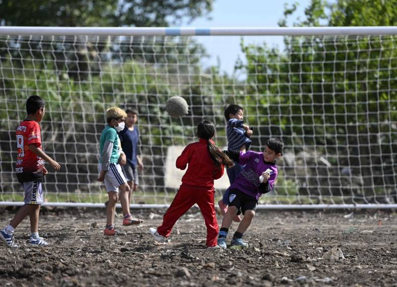 Los niños juegan al fútbol en un campo de tierra llamado en honor al sacerdote católico Bachi, inaugurado durante un evento benéfico en el 60 cumpleaños del exfutbolista argentino Diego Maradona. FOTO AFP