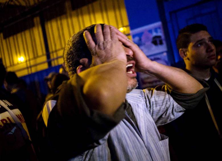 En la noche del domingo, el familiar de uno de los asesinados lloró tras el trágico hecho. FOTO afp