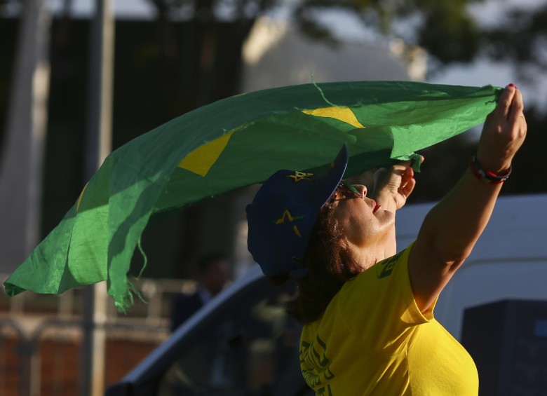 Una manifestante sostiene la bandera de Brasil mientras protesta contra el expresidente de ese país Luiz Inácio Lula da Silva en Brasilia. FOTO AFP