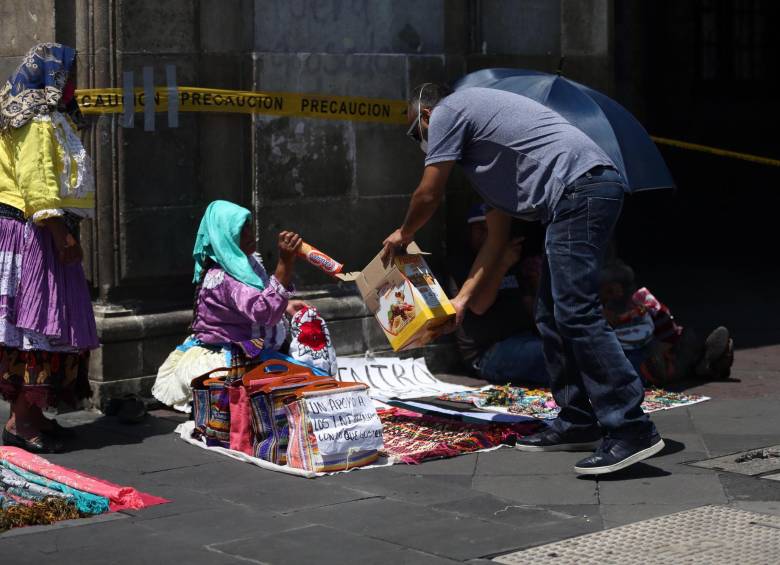 En algunos barrios acomodados y en el centro de Ciudad de México, es común observar indígenas intercambiando artesanías por alimentos productos básicos para su subsistencia. FOTO EFE