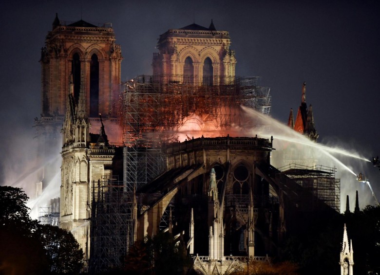 Bomberos continuaban en la noche de este lunes trabajando por apagar las llamas en Notre Dame . FOTO EFE