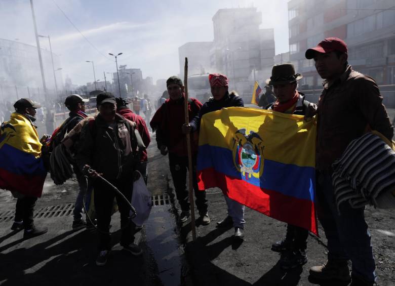 Manifestantes indígenas limpian las calles luego de que se anunciara el fin de las protestas, este lunes, en Quito. FOTO EFE