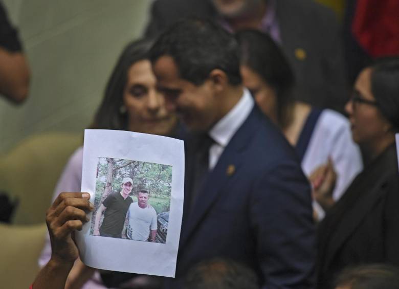 Un diputado progubernamental sostiene imagen de Guaidó posando con un presunto miembro de un grupo paramilitar relacionado con las drogas. FOTO: AFP