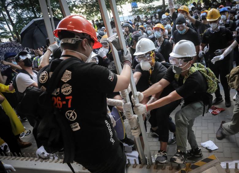 Este es el momento en el que los manifestantes tumban la fachada del parlamento e ingresan al recinto. También pintaron grafitis en el lugar y la policía los reprimió con gases lacrimógenos. FOTO AFP