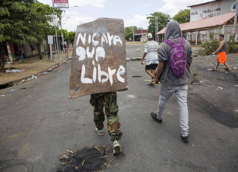Una joven camina en medio de las protestas, que han durado cinco días, en Managua Nicaragua. FOTO EFE