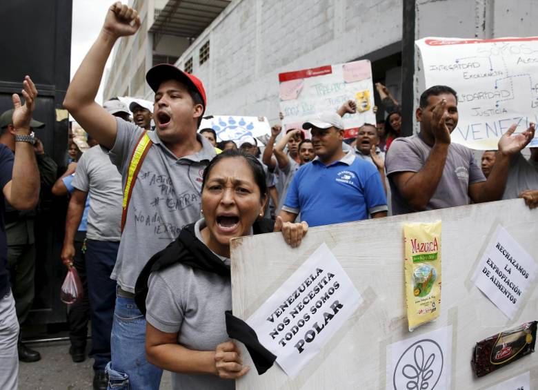Trabajadores de Polar, grupo de compañías que provee alimentos básicos para Venezuela como aceites y harina, protesta ante la decisión del Gobierno de expropiar activos en Caracas. FOTO AFP