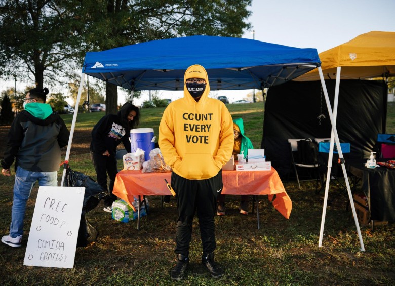 En Durham, Carolina del Norte, activistas entregan comida y refrescos gratis a los votantes. Uno de ellos, en la imagen, luce un buzo con el mensaje “cuenten cada voto”. FOTO EFE