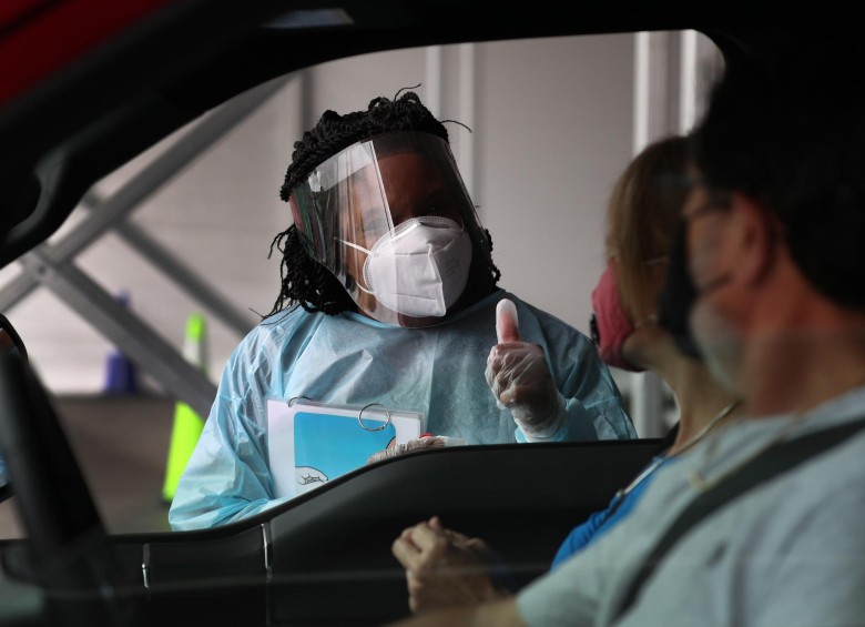 Un trabajador de la salud da un visto bueno después de que las personas usaron hisopos nasales para una prueba autoadministrada en el Auditorio del Condado de Miami-Dade, Florida. FOTO AFP