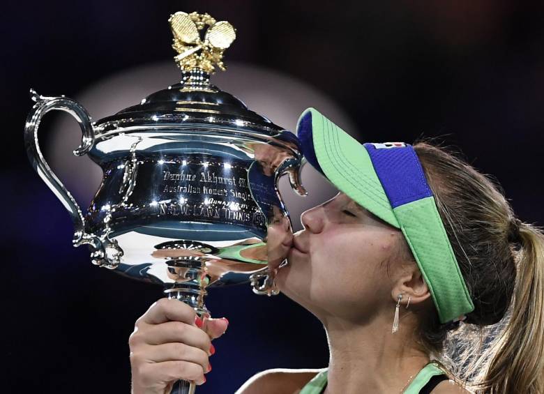 Sofía Kenin besa la Daphne Akhurst Memorial Cup después de ganar contra la española Garbine Muguruza en su último partido de singles femeninos. FOTO AFP