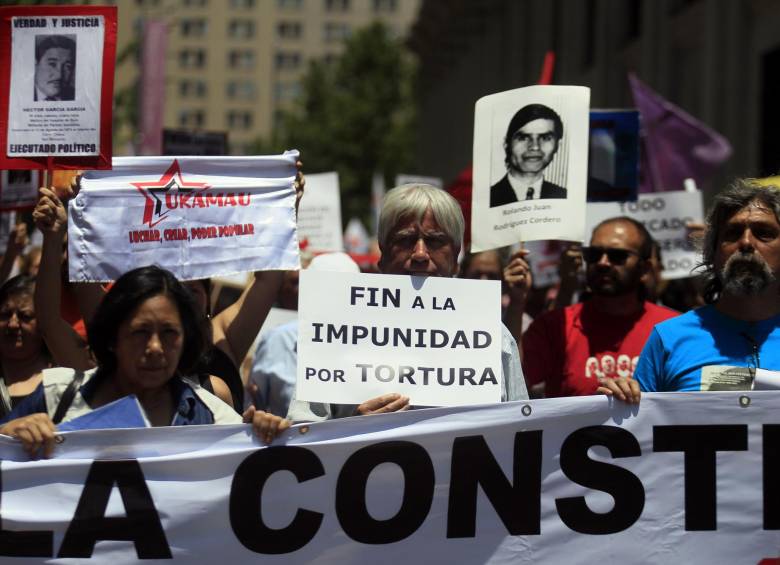 Cientos de personas marcharon con carteles con fotos de víctimas de la dictadura de Augusto Pinochet en Santiago, Chile, coreando consignas contra Pinochet y pidiendo justicia por crímenes contra los derechos humanos de la dictadura. FOTO AP