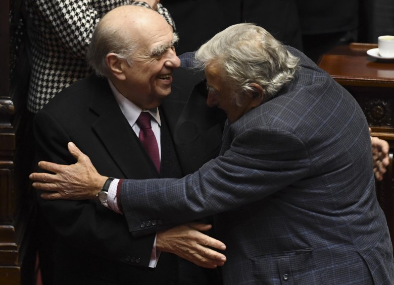 Julio Sanguinetti y José Mujica, saltándose los protocolos de bioseguridad, se dieron un abrazo al momento de anunciar su renuncia. FOTO AFP