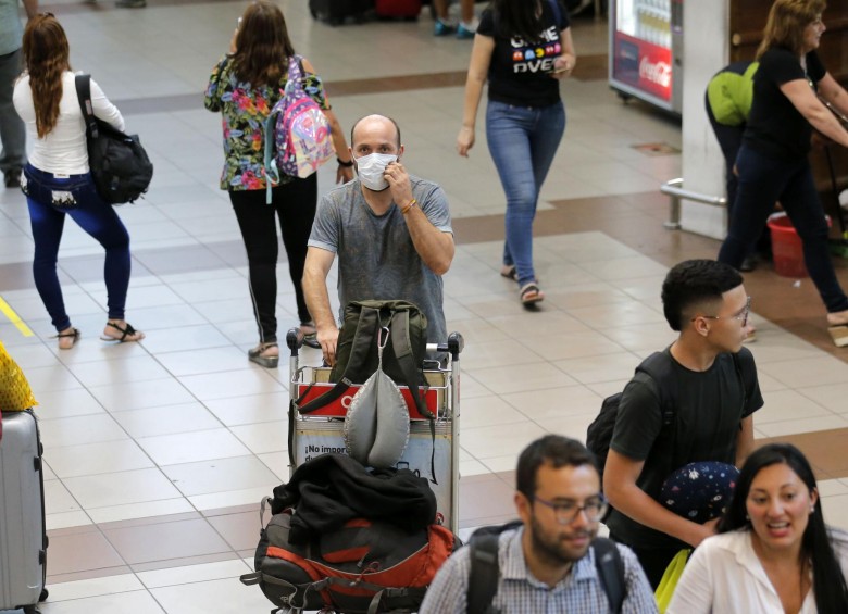 Un pasajero en el aeropuerto Arturo Merino, de Santiago, usa tapabocas como precaución ante los casos de contagio de coronavirus en Chile. FOTO AFP