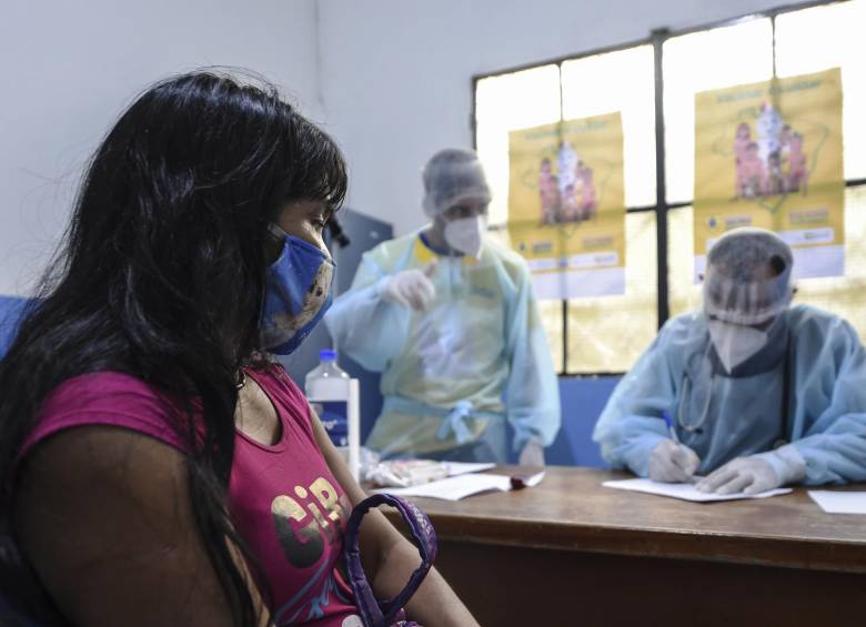 Una indígena brasileña, del grupo étnico Marubo, es notificada de que contrajo el nuevo coronavirus por un miembro del equipo médico de las Fuerzas Armadas de Brasil en el estado de Amazonas, norte de Brasil. FOTO AFP