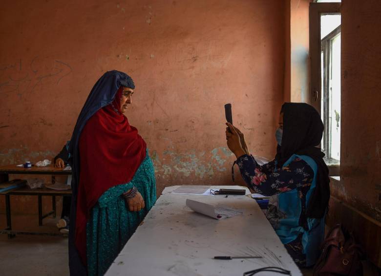 Un funcionario de la Comisión Electoral Independiente (IEC) escanea la cara de un votante con un dispositivo biométrico en una mesa electoral en Mazar-i-Sharif. FOTO AFP