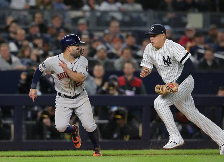 José Altuve (Astros) y Giovanny Urshela (Yanquis) durante el caurto juego de la Serie de Campeonato que sacó adelante el equipo “cohete” 8-3 y va adelante 3-1. FOTO REUTERS
