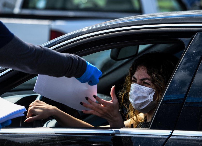 Una mujer recibe los formularios necesarios para solicitar un subsidio de desempleo en Florida. FOTO AFP