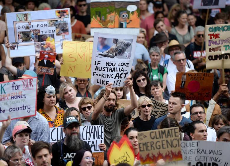 Manifestantes sostienen pancartas sobre el cambio climático en Sídney, Australia. FOTO EFE 