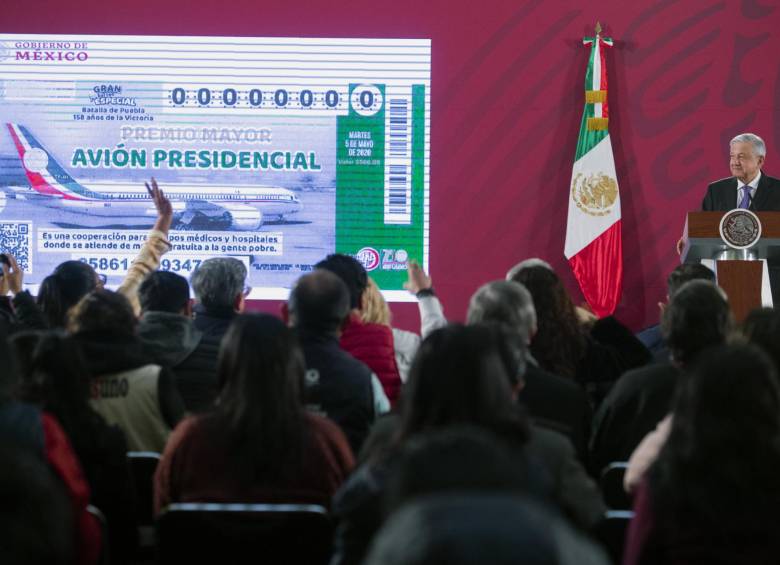 El presidente de México, Andrés Manuel López Obrador, presenta el boleto de la rifa del avión presidencial. FOTO: AFP