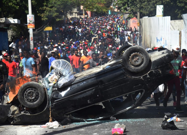 Un carro volcado usaron los manifestantes de Puerto Príncipe como barricada en las protestas contra el presidente. FOTO afp