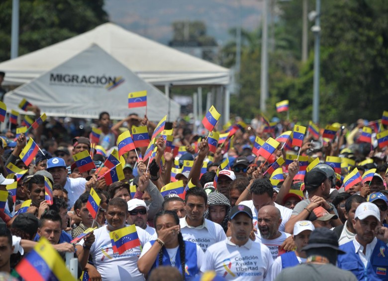 Personas con banderas de Venezuela esperan para apoyar la caravana de ayuda humanitaria. FOTO AFP