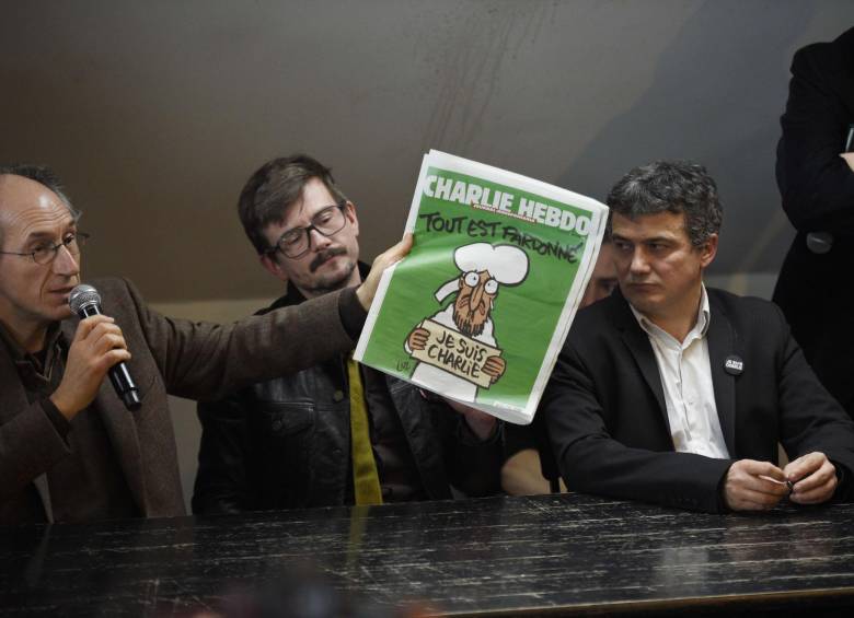 Parte del equipo que continúa trabajando: el editor jefe Gerard Briard (izquierda), el caricaturista Renald Luzier (centro), y el editorialista Patrick Pelloux (derecha), presentando la edición. FOTO afp 