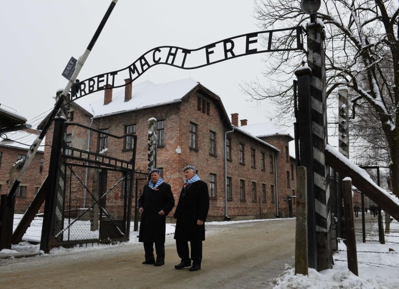 Varios de los supervivientes de Auschwitz pasaron ayer por la infame inscripción de su entrada.