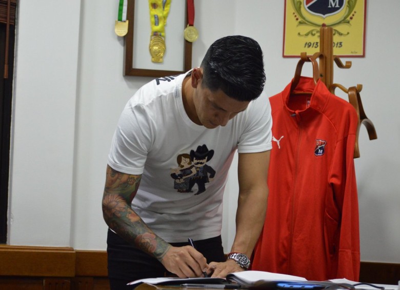 El delantero Germán Ezequiel Cano firmando el nuevo contrato que lo vincula por un año más con el DIM. FOTO CORTESÍA DIM