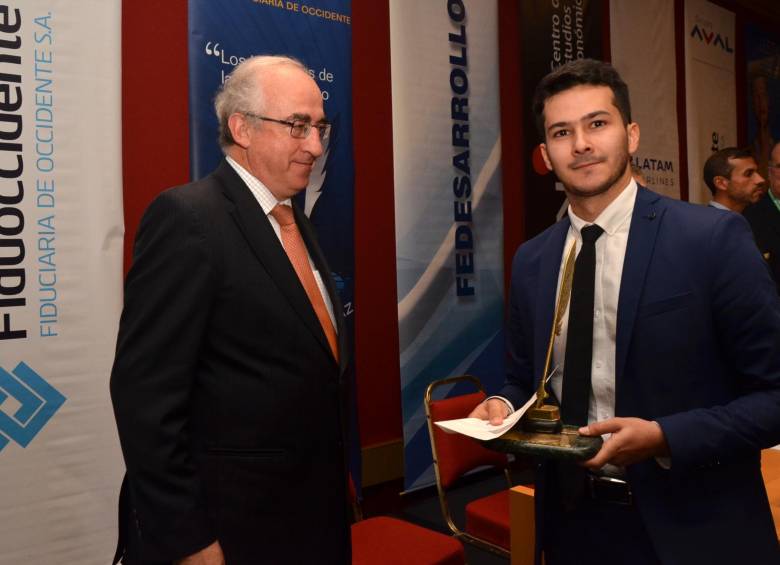 El periodista económico David Ortiz recibió del director de Fedesarrollo, Leonardo Villar, el premio Anif 2016. FOTO cortesía anif