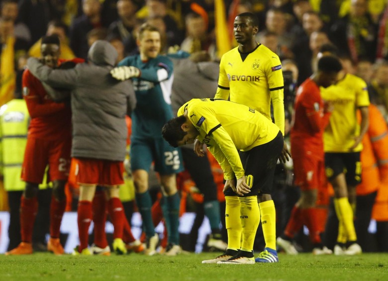 La tristeza de Adrián Ramos contrasta con la alegría, en el fondo de la imagen, de los jugadores del Liverpool inglés, que salvaron un partido controlado por los alemanes. FOTO reuters
