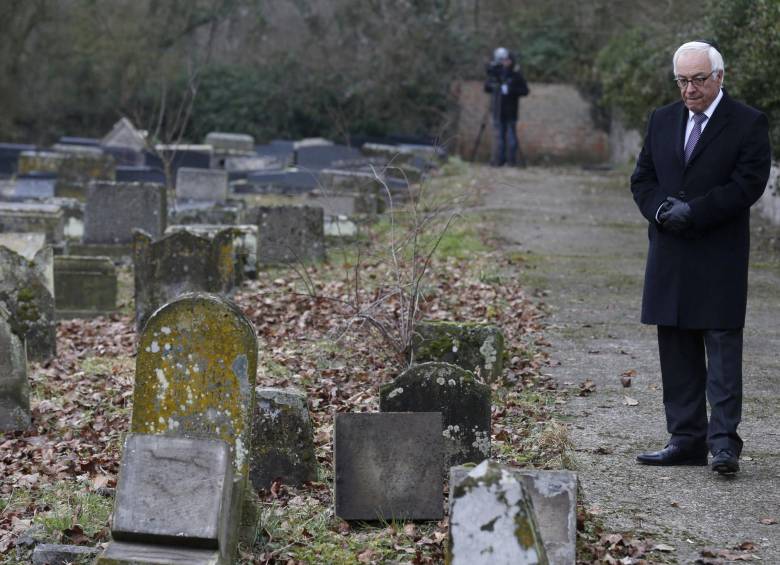 El embajador israelí en Francia, Yossi Gal, camina cerca de algunas de las tumbas profanadas en un cementerio en el este del país galo. FOTO AFP